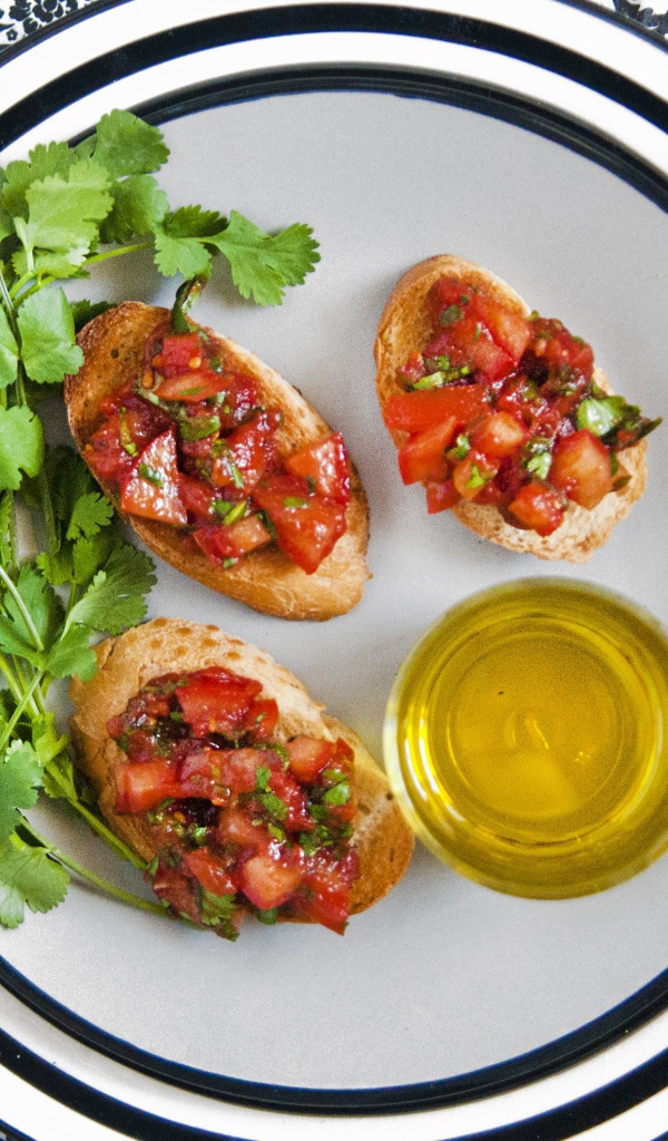 Бутерброды с помидорами на тарелке с петрушкой и маслом