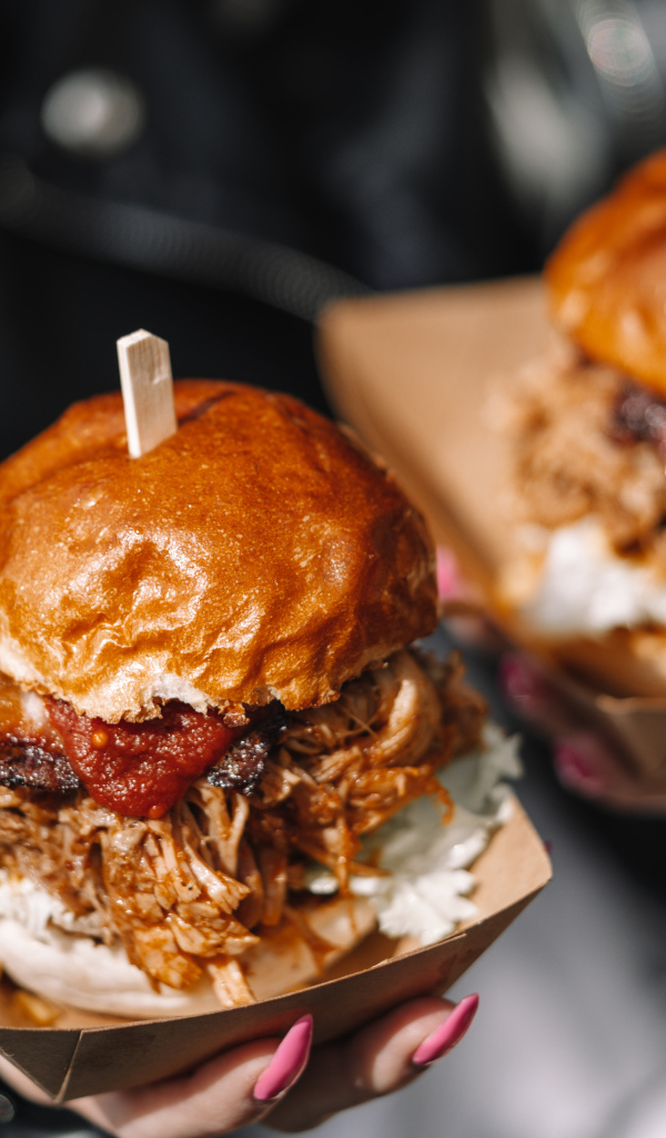 Два гамбургера в коробках в руках у девушки