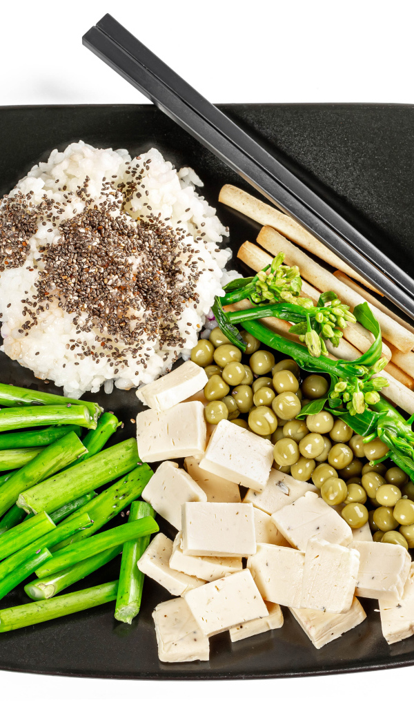 Овощи, сыр и рис на тарелке с палочками