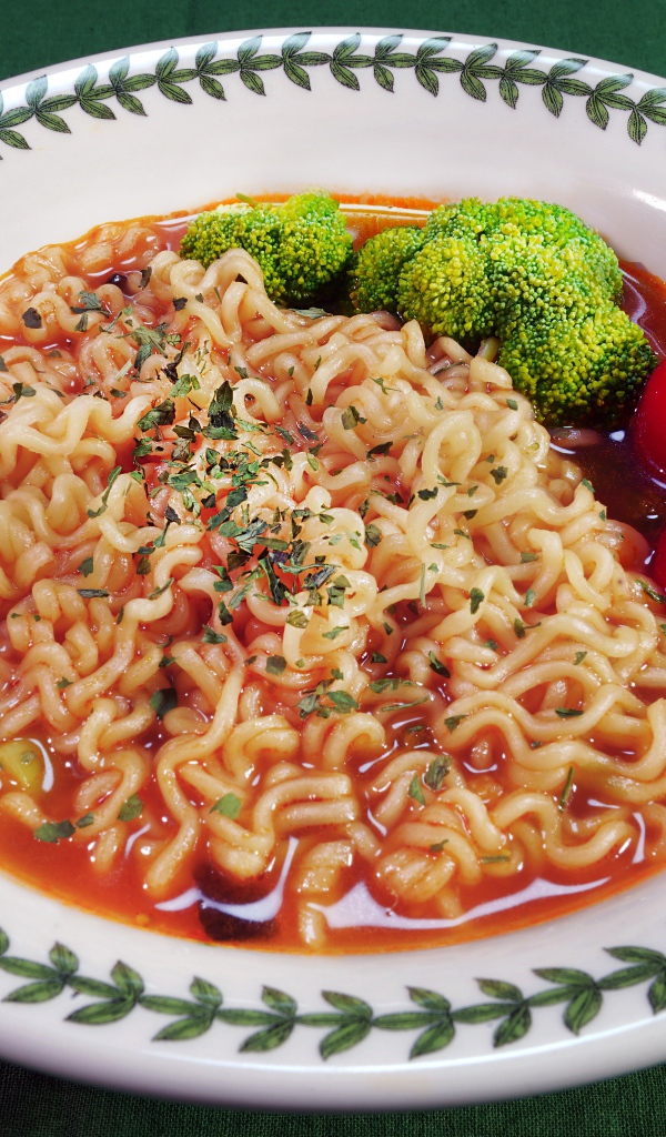 Вермишель с соусом в тарелке с помидорами