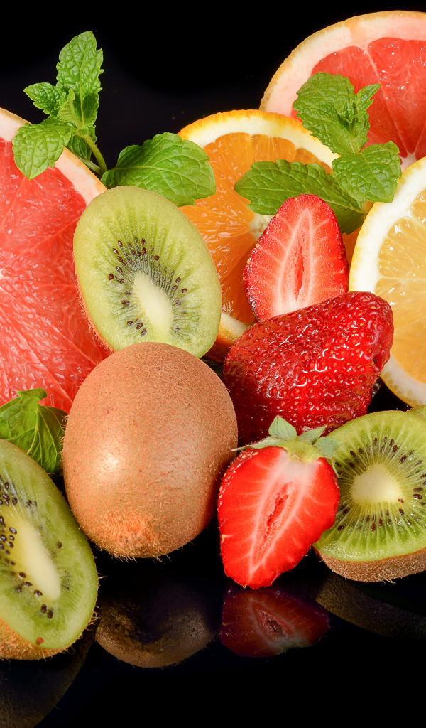 Цитрусовые фрукты с клубникой на черном фоне