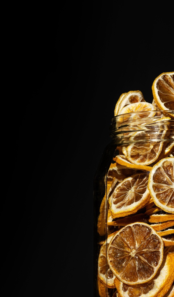Сушеные лимоны в банке на черном фоне