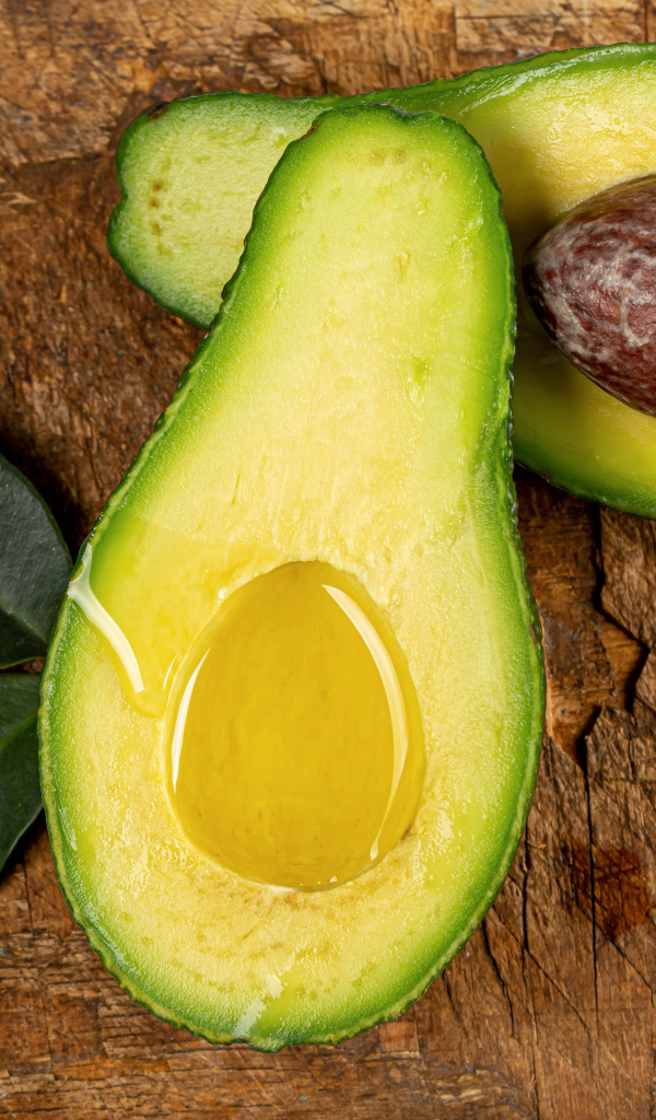 Зеленое авокадо на деревянном столе