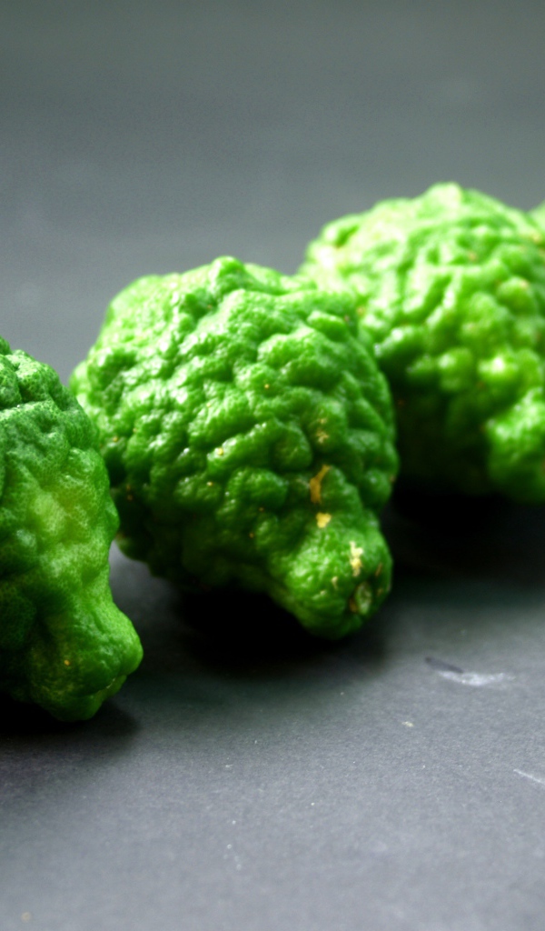 Зеленые плоды бергамота на серой поверхности