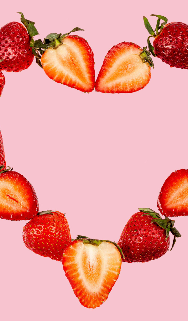 Сердце из клубники на розовом фоне 