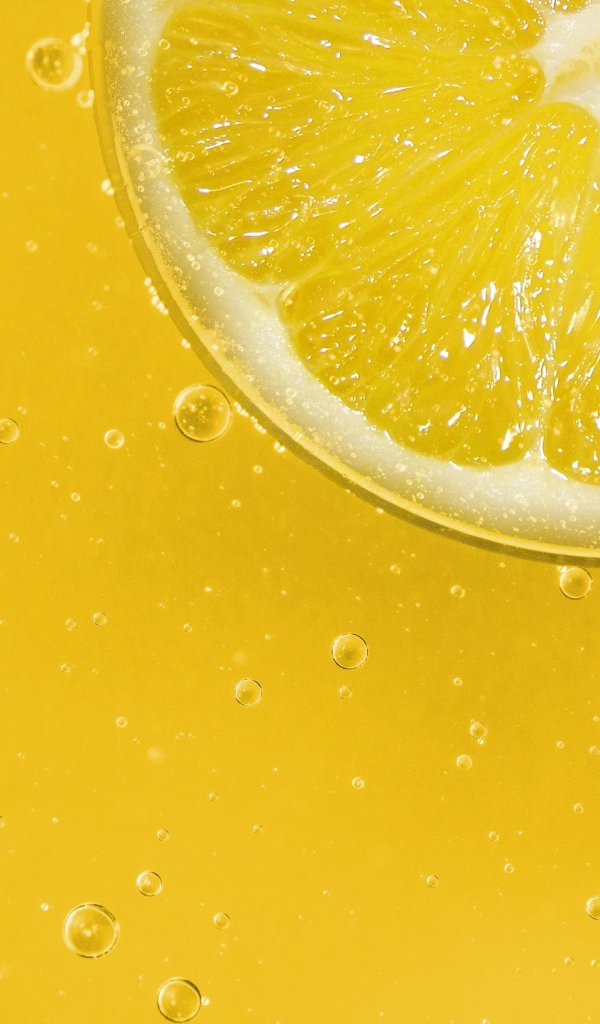Лимон на желтом фоне с каплями воды