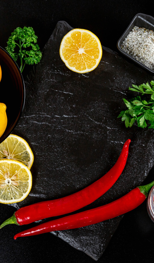 Лимоны на столе с красным перцем, петрушкой  и специями