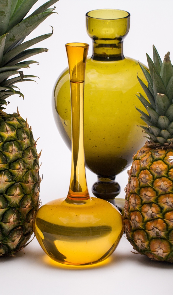 Ананасы на столе с маслом и ромашками