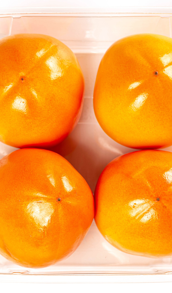 Спелая хурма с лотке на белом фоне