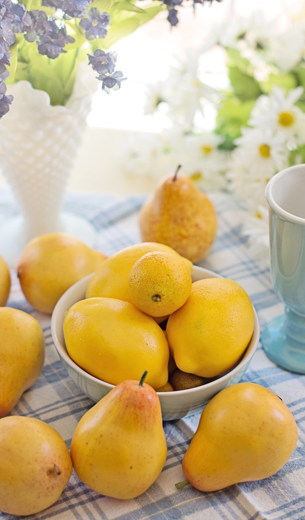 Спелые желтые груши на столе с цветами 