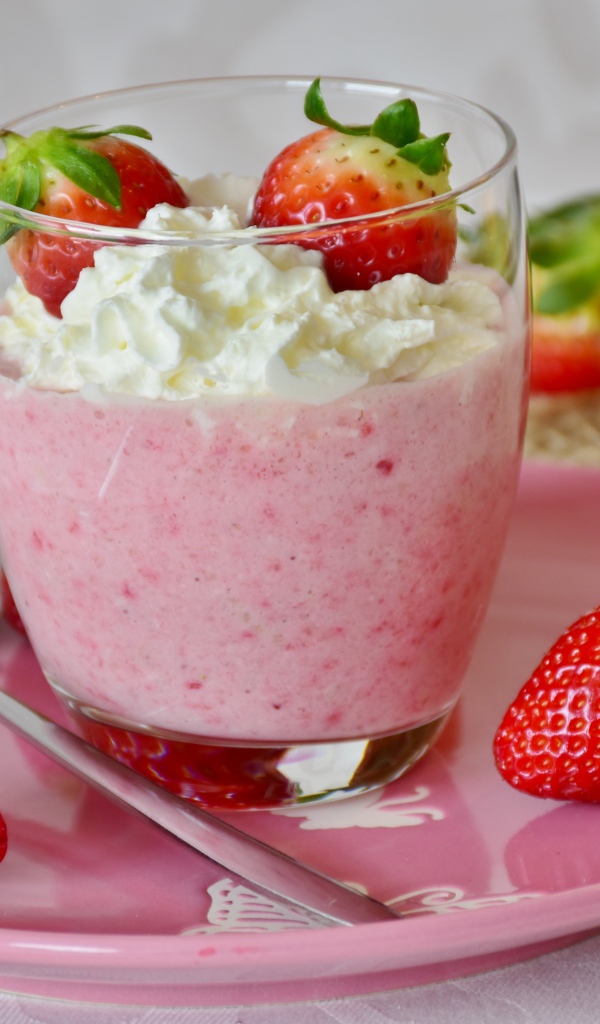 Ягоды клубники со взбитыми сливками на столе 