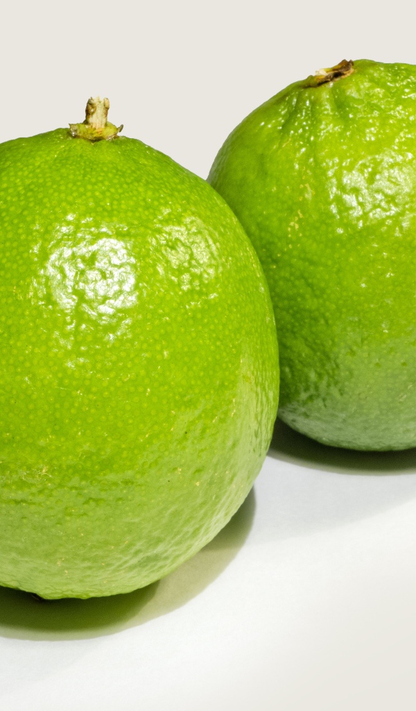 Два больших зеленых лайма на столе