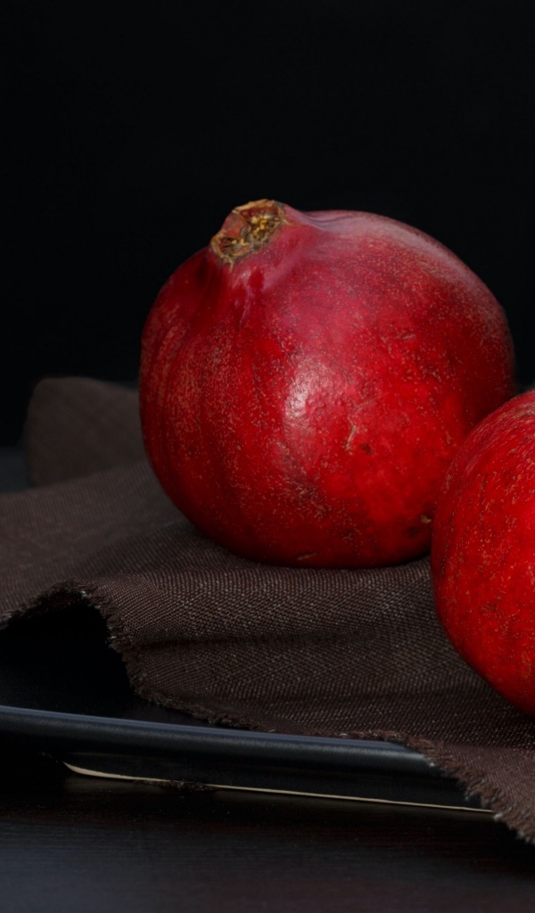 Два красных граната на столе