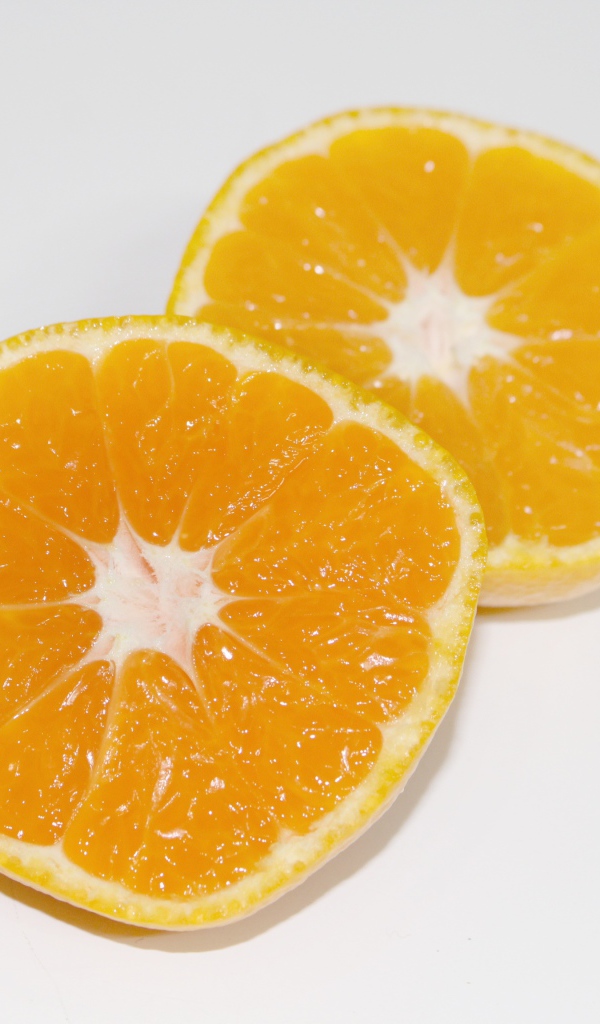 Два кружочка мандарина на сером столе 