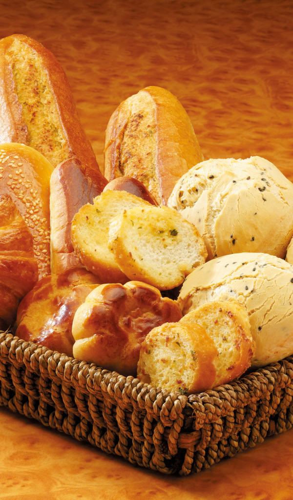 Вкусная свежая выпечка в корзине на столе 