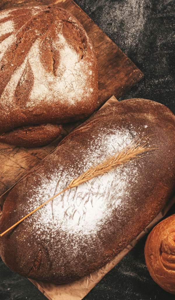 Свежий хлеб и булочки на разделочной доске