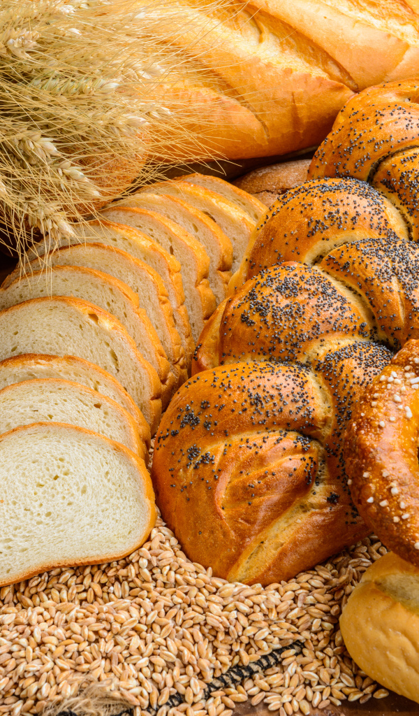 Свежая выпечка на столе с колосьями и зернами пшеницы 