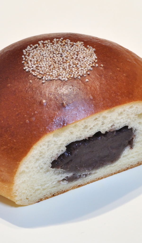 Свежая румяная булочка с вареньем на белом фоне