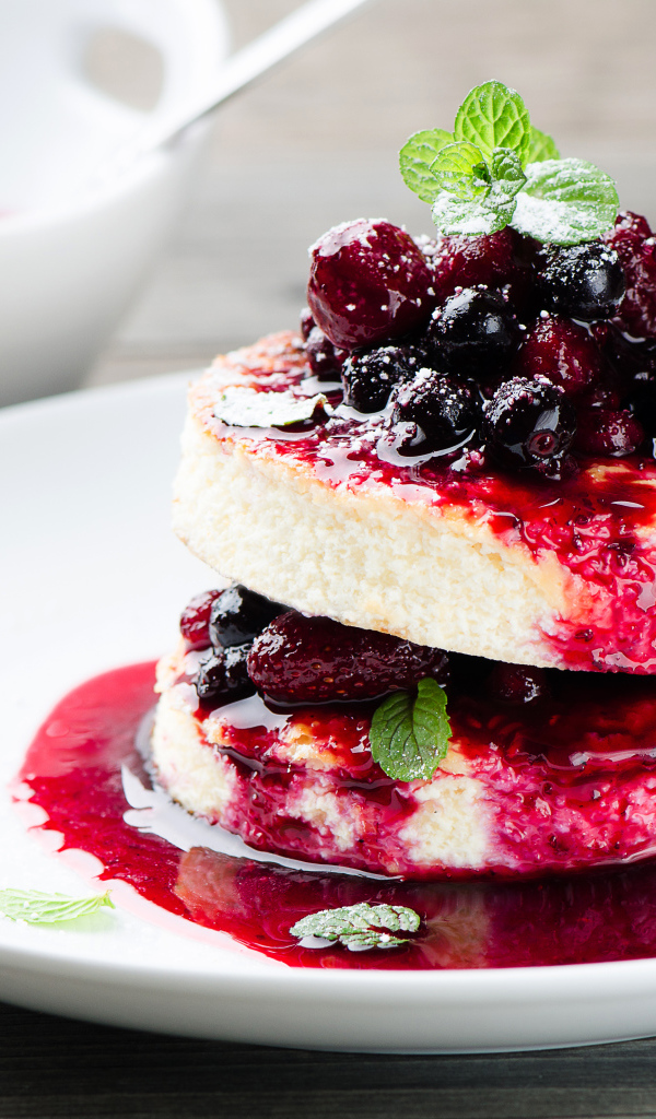 Аппетитные сырники с ягодами на белой тарелке 