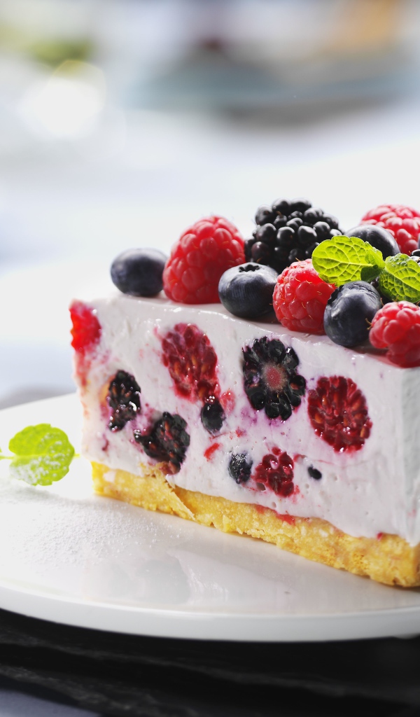 Аппетитный торт-суфле с ягодами на белой тарелке