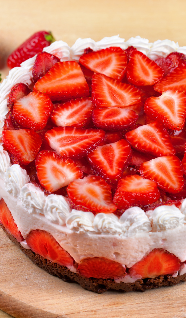 Красивый торт с кремом и ягодами клубники на доске