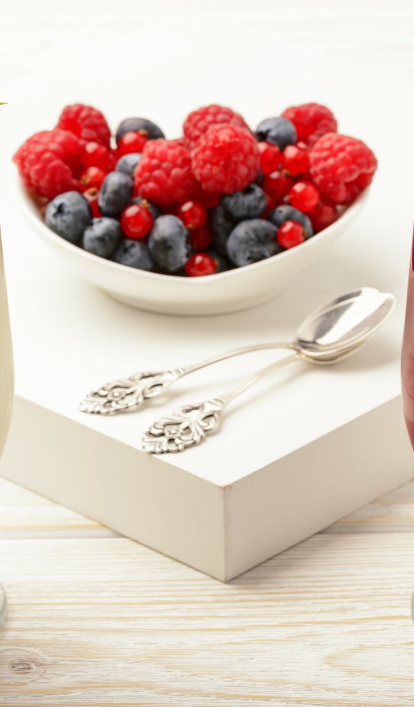 Двухцветный десерт с ягодами на столе 