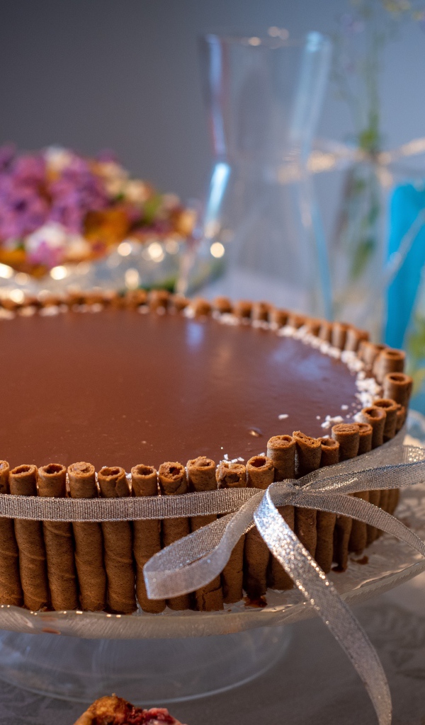 Большой шоколадный торт с трубочками на столе
