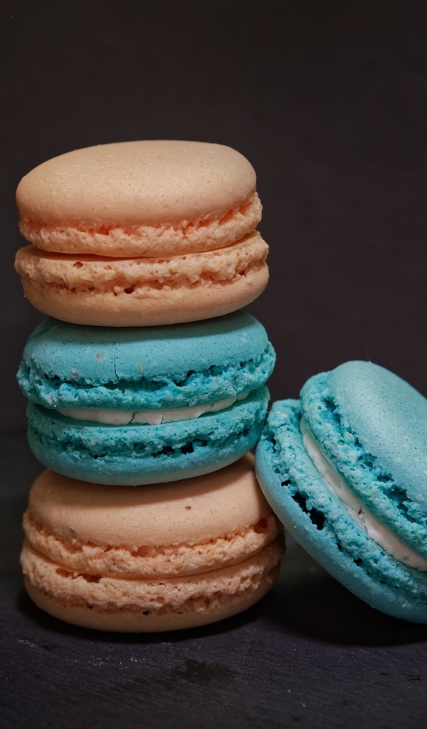 Голубой и коричневый десерт макарун на сером фоне