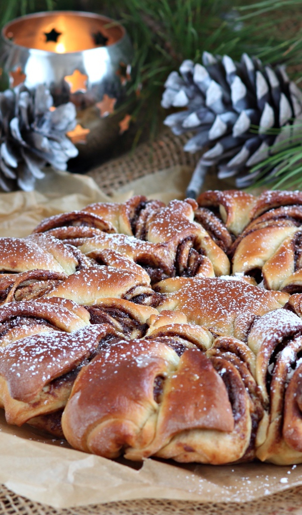 Сдобный венок с вареньем на столе с шишками