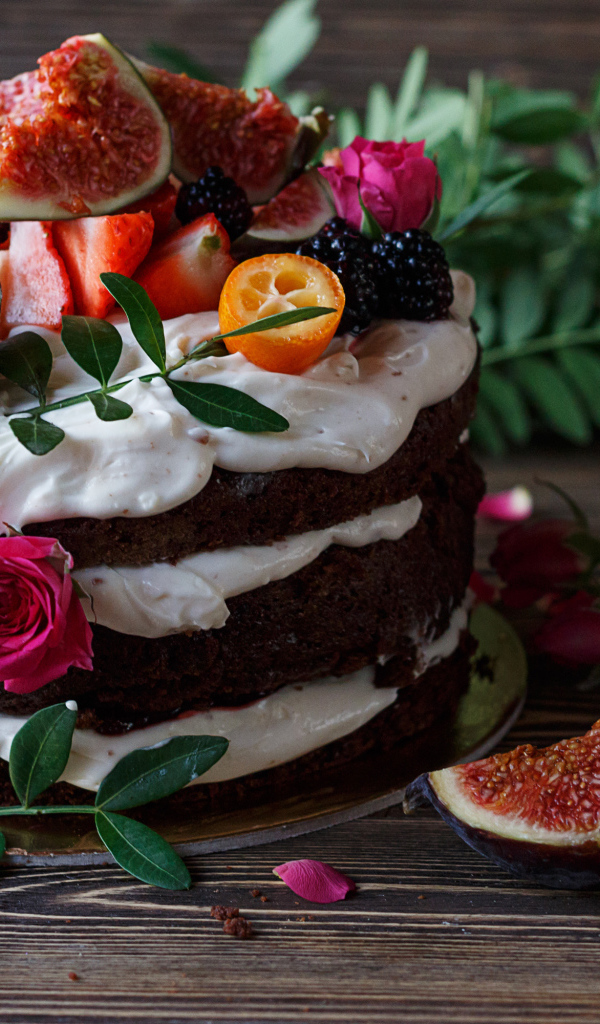 Торт с шоколадными коржами и сливочным кремом украшен ягодами