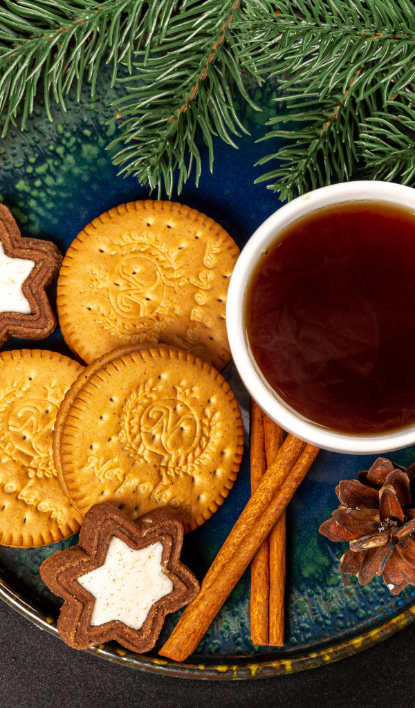 Печенье, чай и корица на столе с еловой веткой