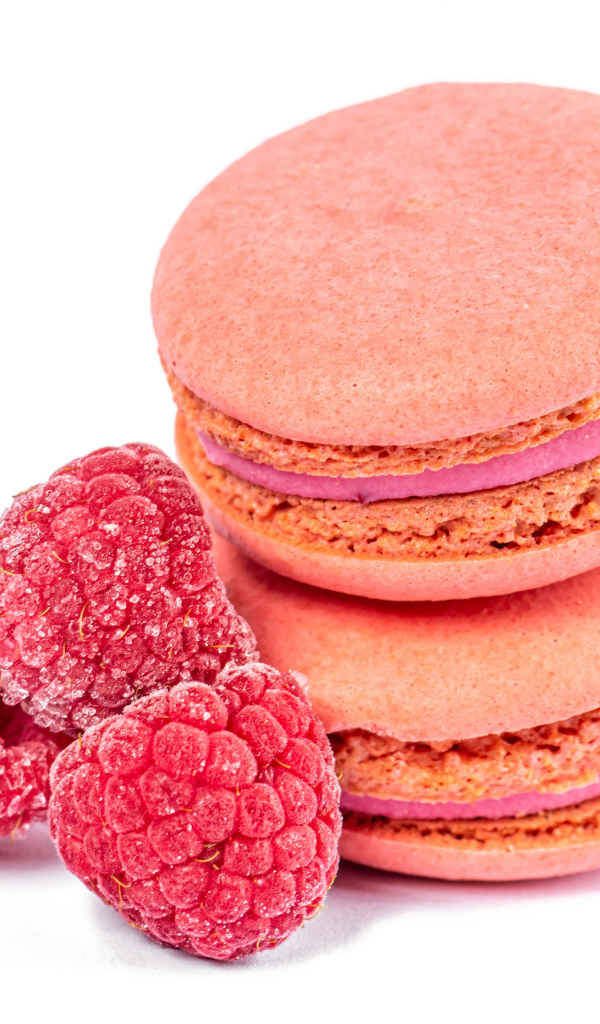 Десерт макарон с малиной на белом фоне