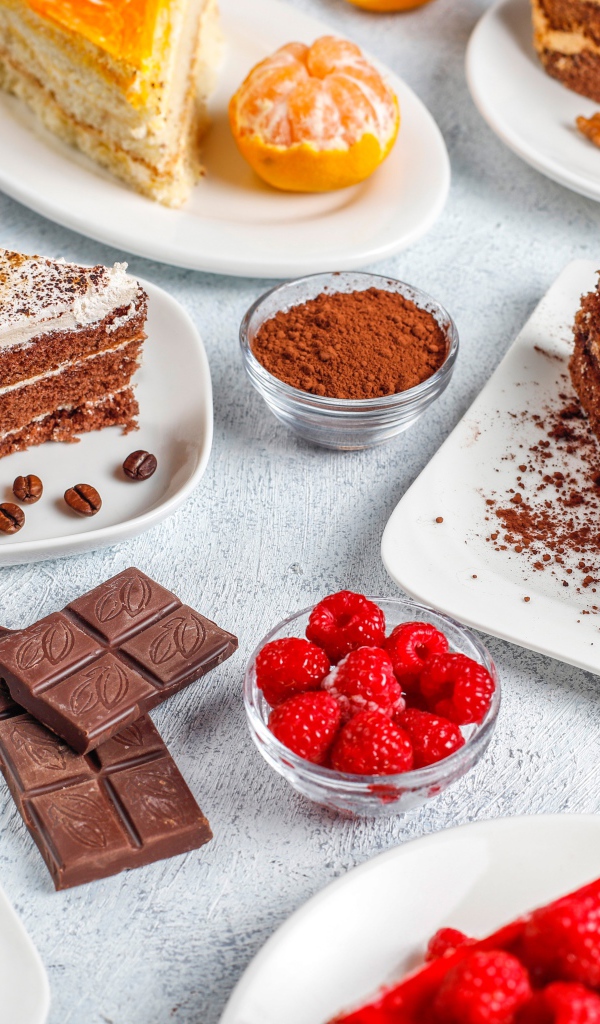 Разные куски торта на столе с малиной и шоколадом 