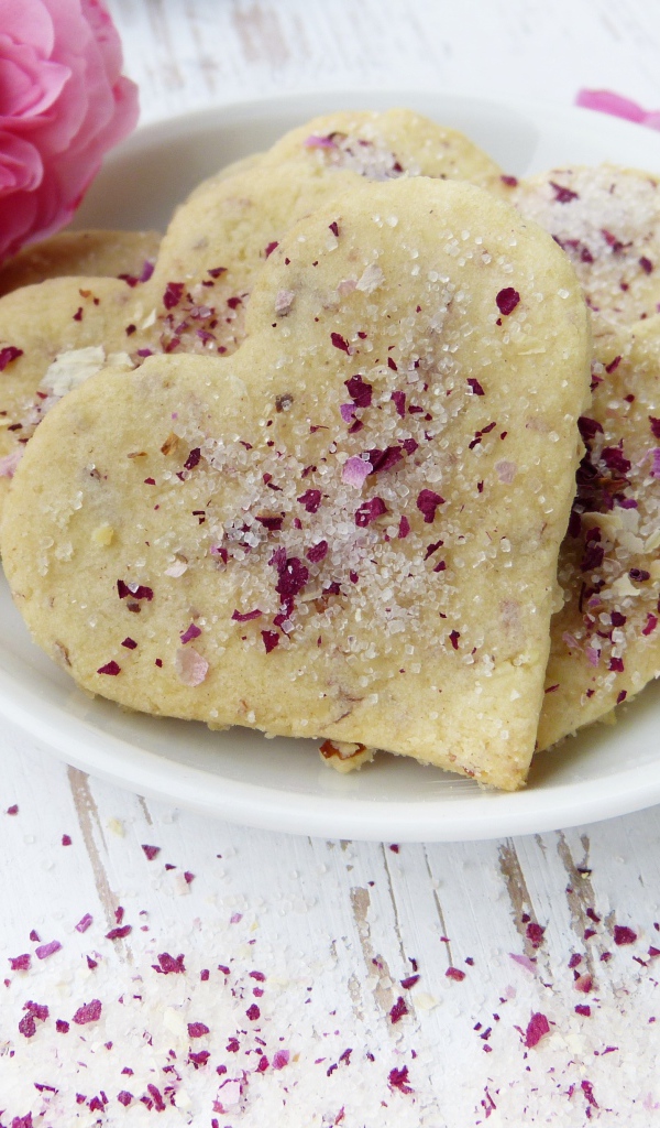 Песочное печенье в форме сердца в белой тарелке с цветами