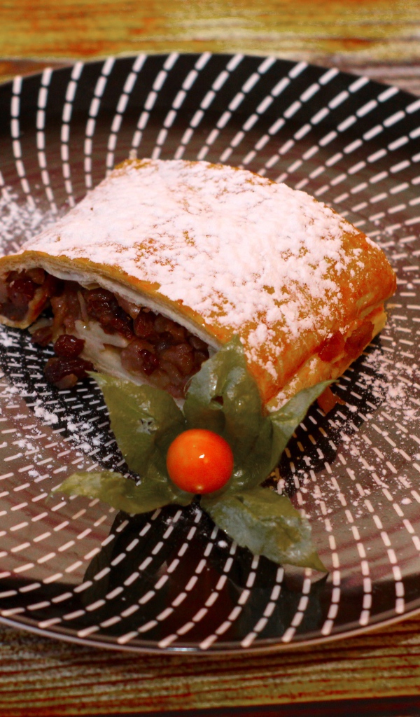 Кусок яблочного штруделя на тарелке 