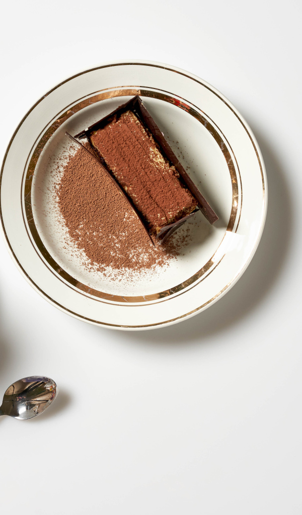 Кусок торта на столе с чашкой кофе 