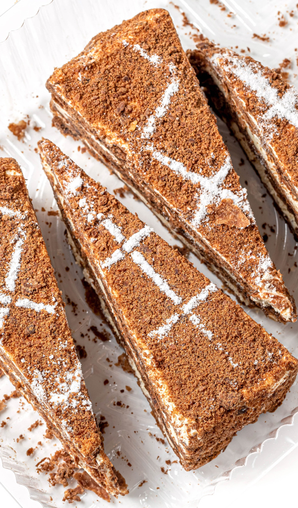 Куски аппетитного медового торта на белом фоне