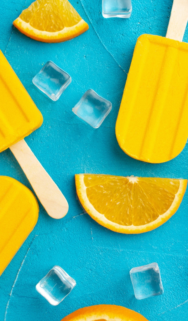 Фруктовое мороженое с кусочками льда и апельсина на голубом столе 