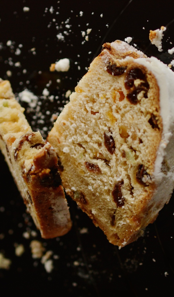 Два куска кекса с изюмом на черном фоне 