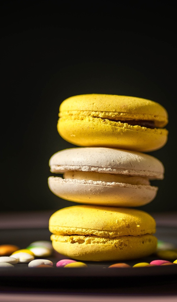 Желтый десерт макарун на тарелке