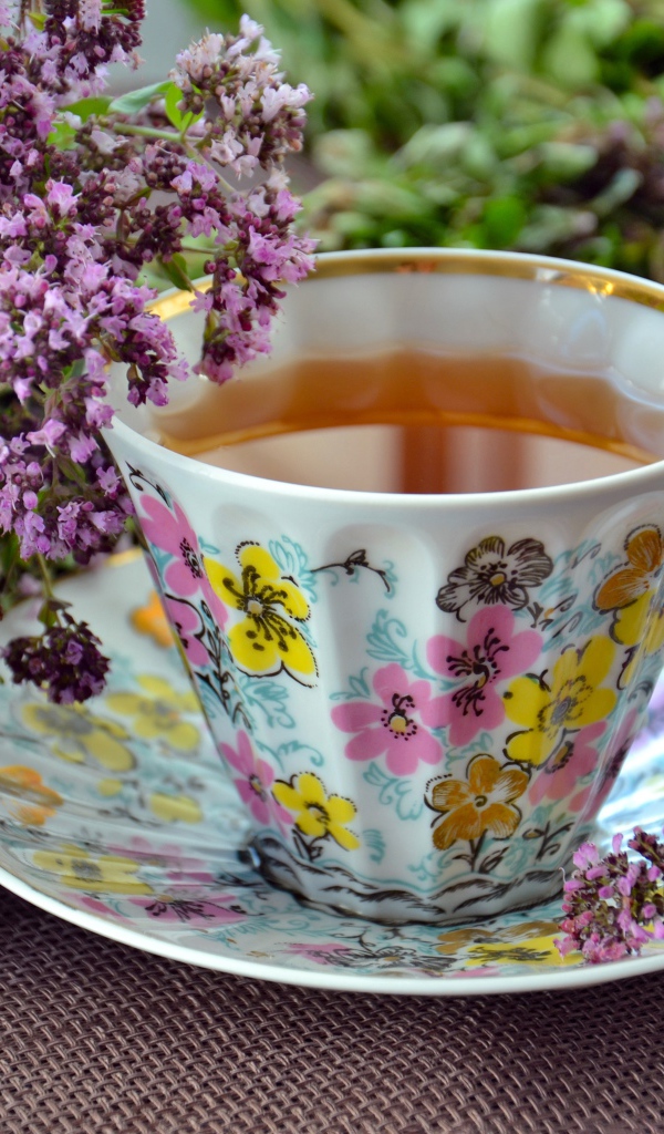 Чашка чая с цветами мяты на столе