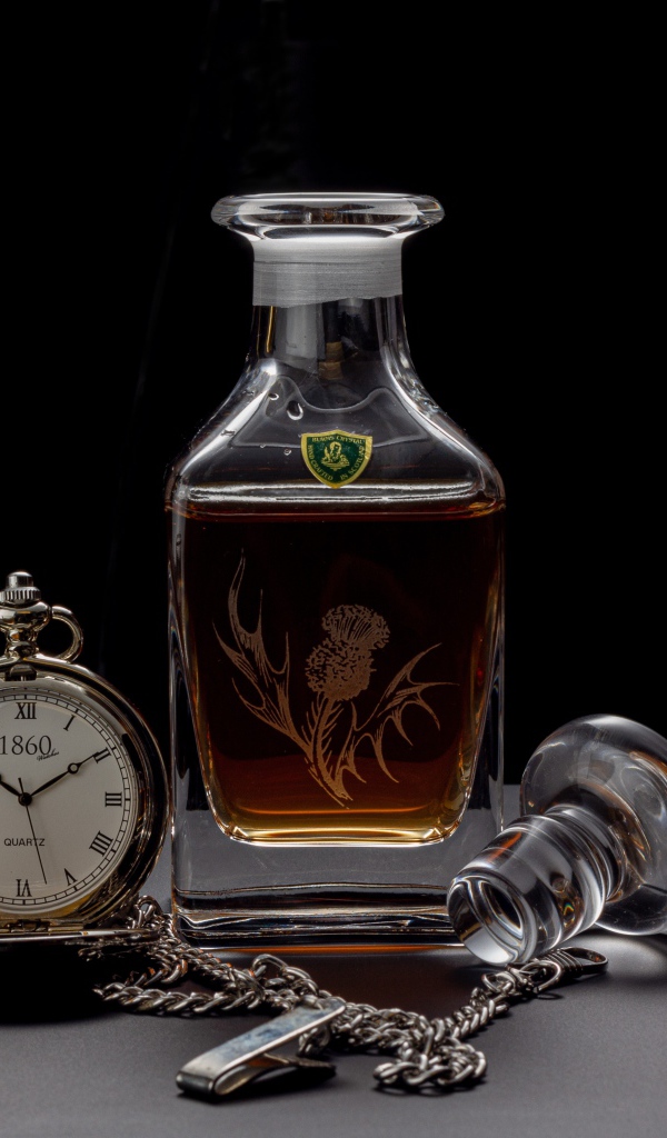 Дорогой коньяк на столе с карманными часами 