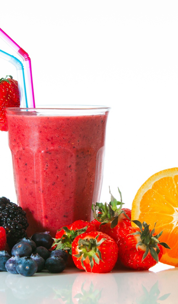 Стакан свежего смузи на столе с ягодами