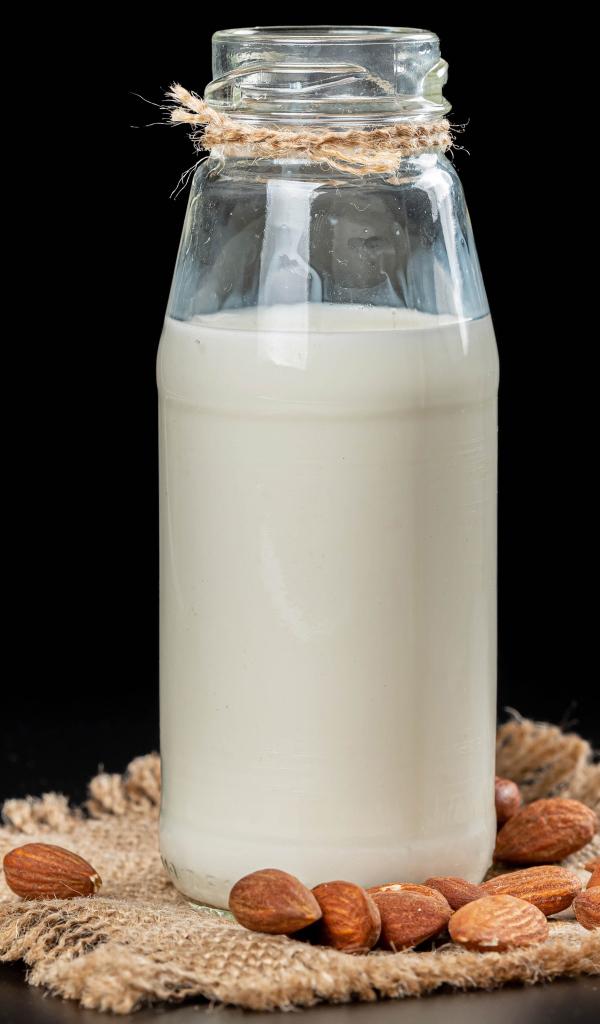 Молоко с миндалем на черном фоне