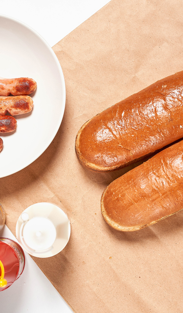 Hot dog rolls with sausages on the table with sauce