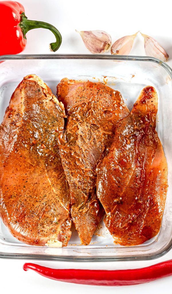 Маринованное мясо на столе со специями и соусом