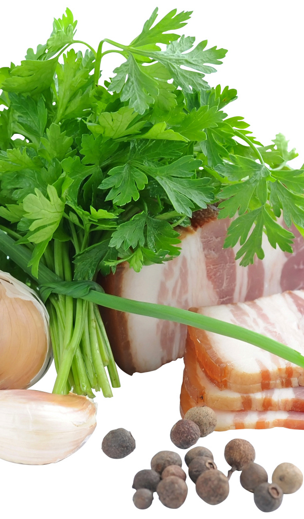 Кусок сала на белом фоне с зеленью петрушки и специями