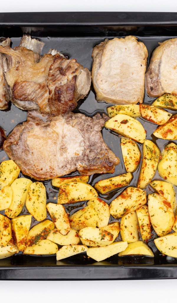 Свинина на противне с картофелем на белом фоне 