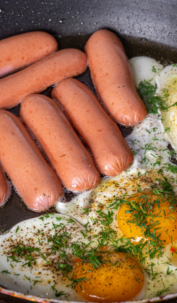 Сосиски с яичницей на сковороде