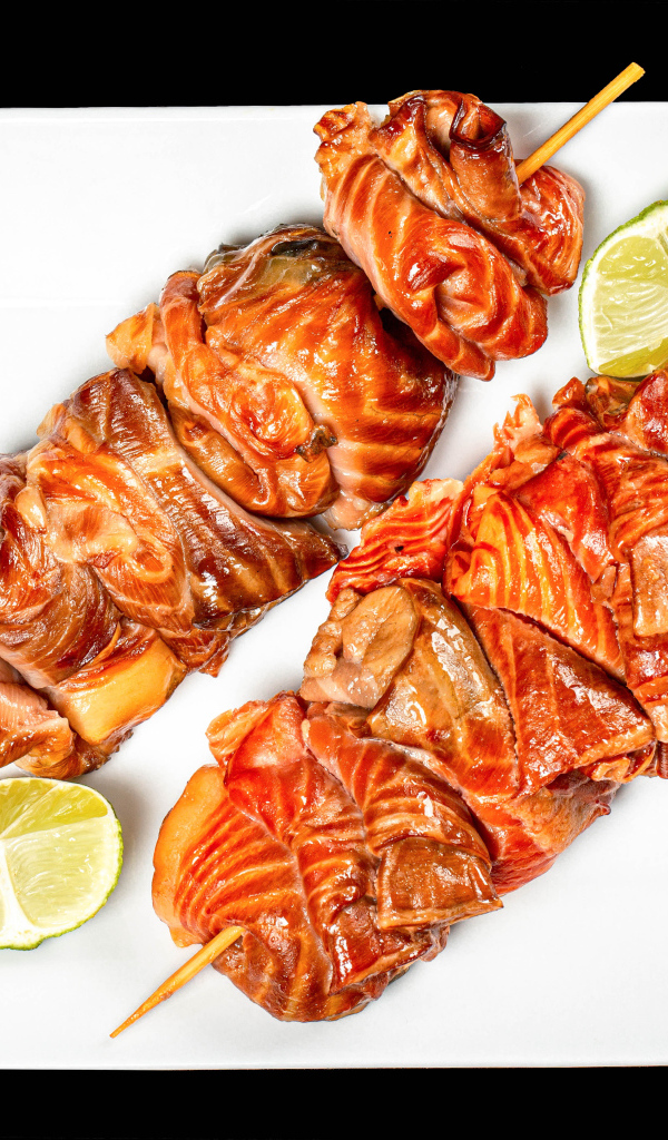 Шашлык на шпажках на белой тарелке с лимоном